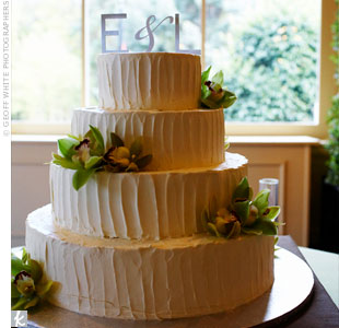 Cymbidium orchids and a brushed-metal monogram topper finished off the four-tiered buttercream cake.